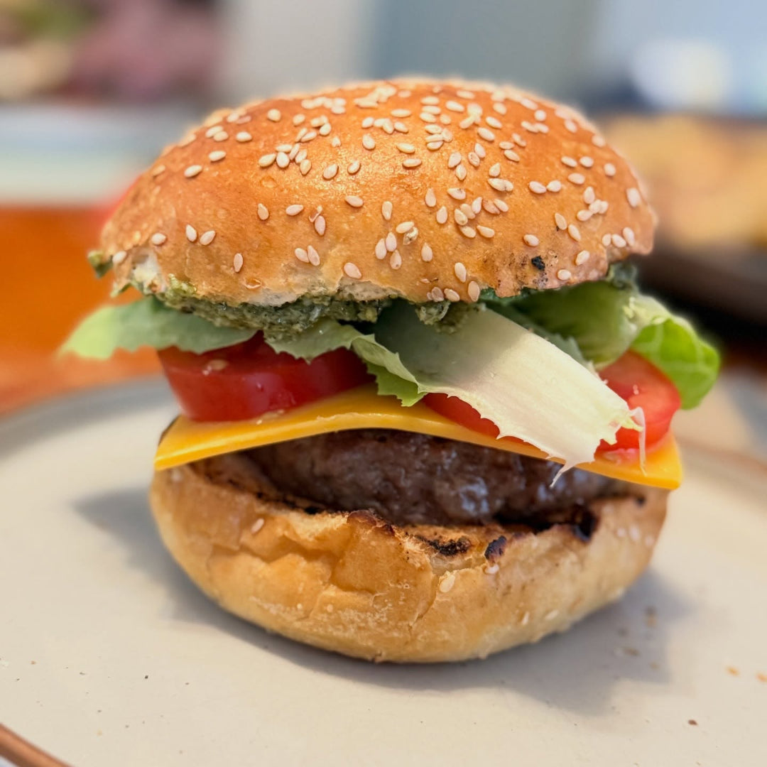 Circle F Beef | Hamburger with sesame seed bun on a plate with a blurred background