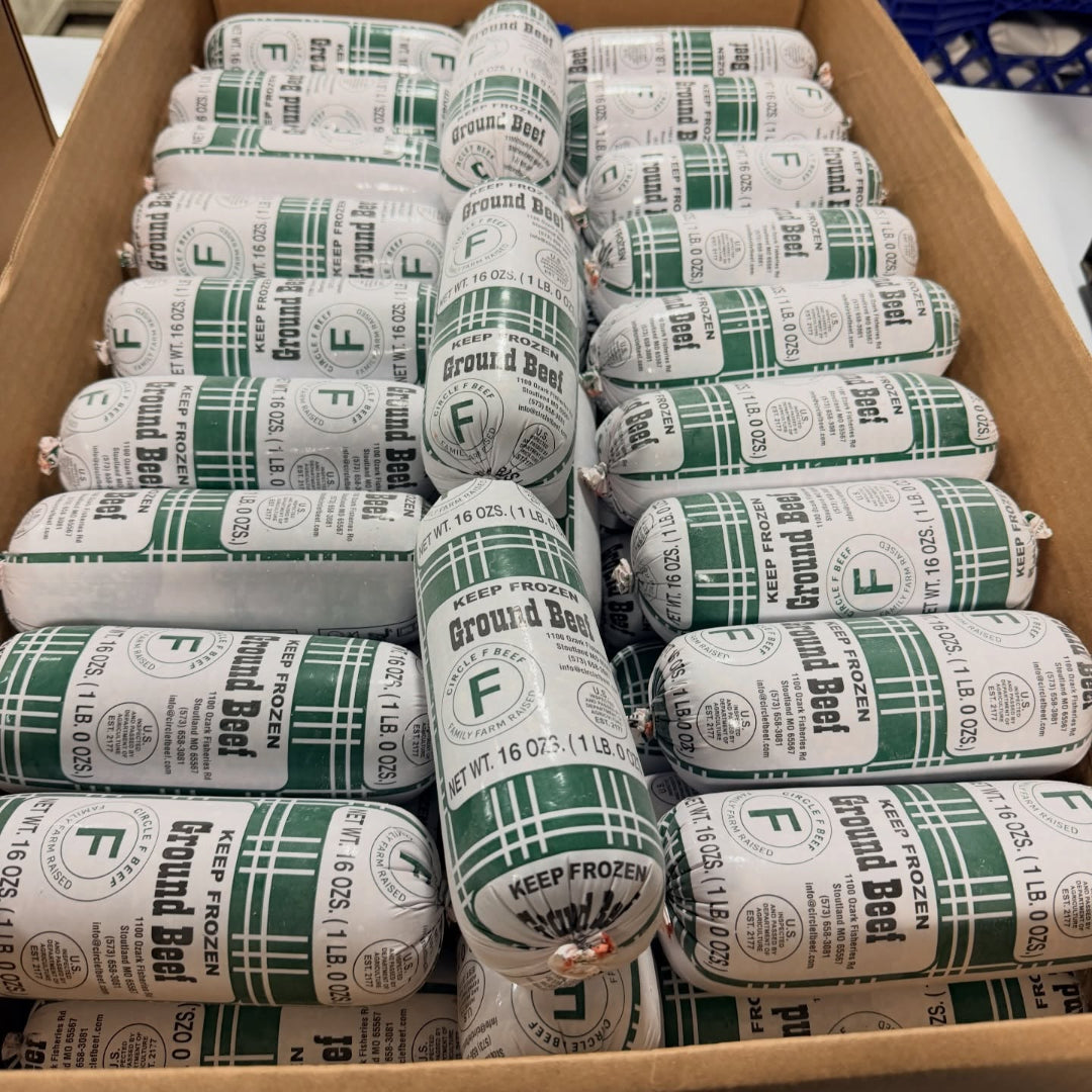 Circle F Beef Multiple packages of ground beef in green and white packaging stacked in a cardboard box.